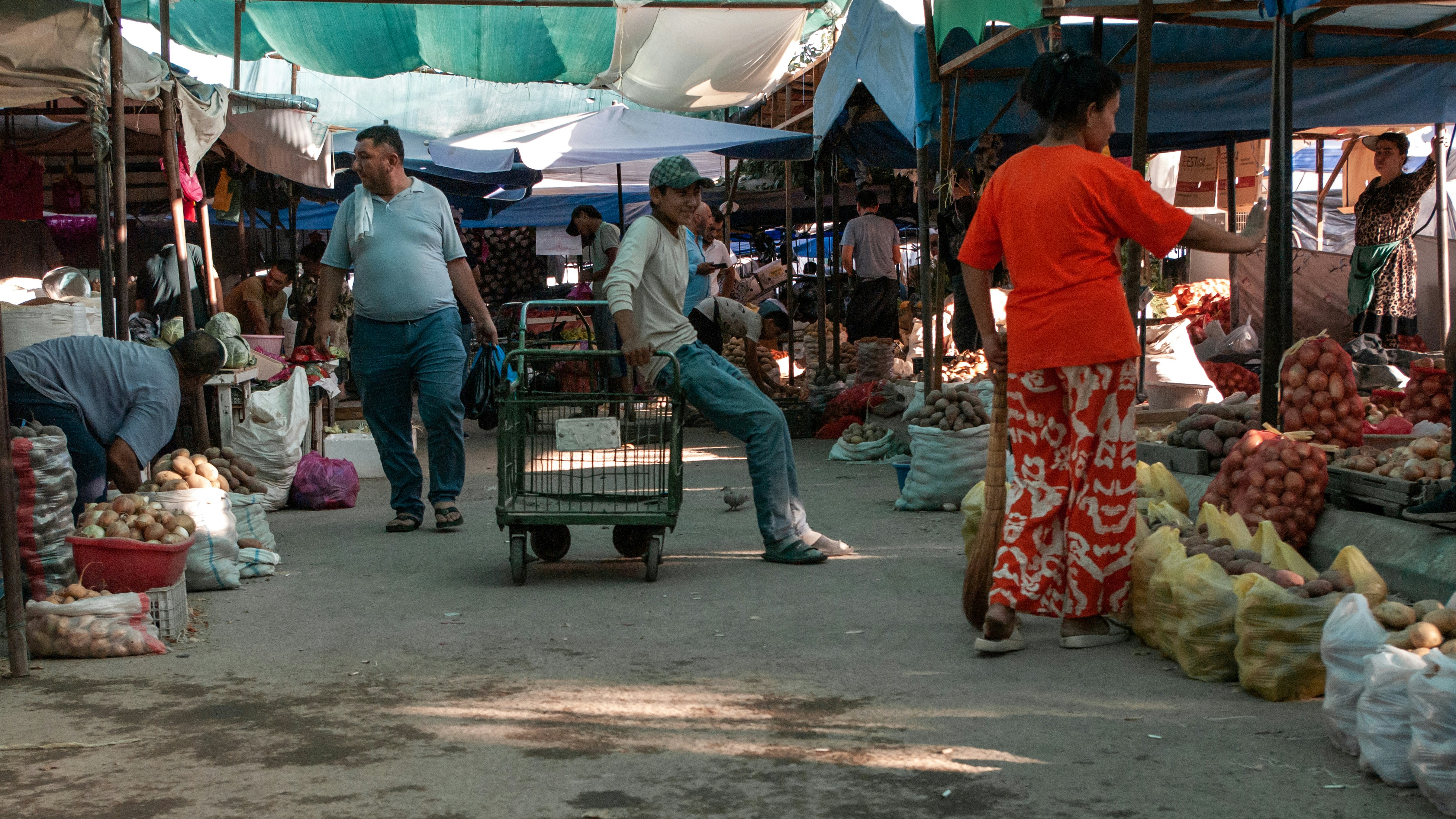 People are shopping and working at a bustling market.